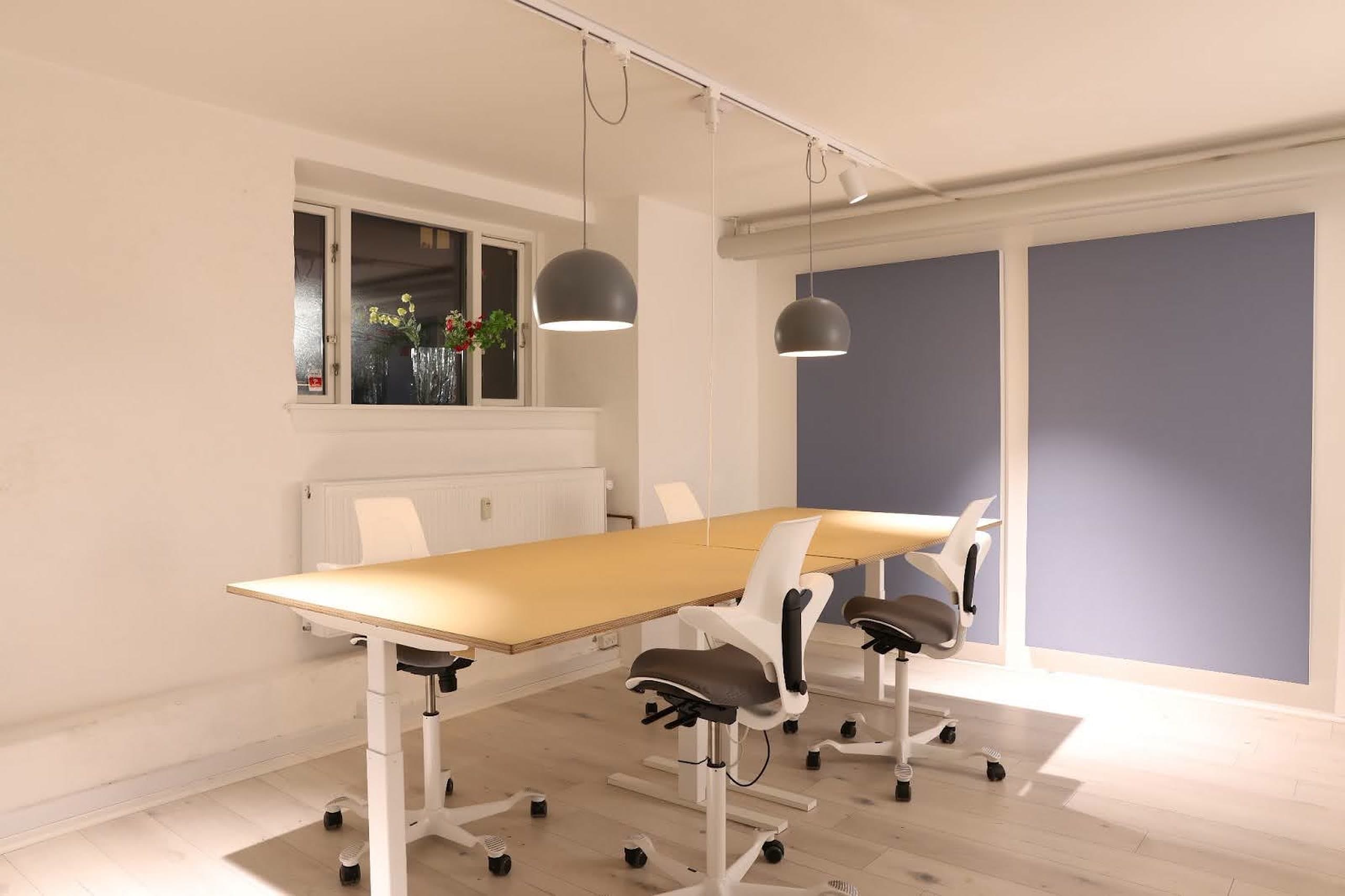 The Office mødelokale på Frederiksberg med massivt træbord, designerstole og pendellamper